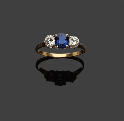 Lot 363 - A Sapphire and Diamond Three Stone Ring, the oval cut sapphire flanked by a round brilliant cut...