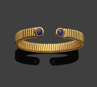 Lot 367 - An 18 Carat Gold Flexible Bangle, the open linked bangle set with a cabochon sapphire at each...