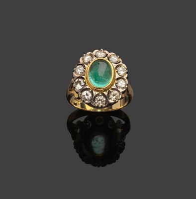 Lot 372 - An Emerald and Diamond Cluster Ring, an oval cabochon emerald in a yellow rubbed over setting...