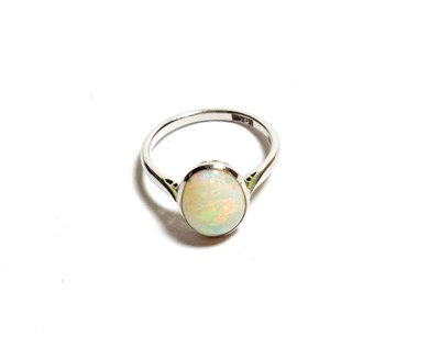 Lot 115 - An opal ring, the oval cabochon opal in a white millegrain setting to a tapered shoulder plain...