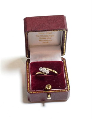 Lot 120 - An 18 carat gold diamond three stone twist ring, the round brilliant cut diamonds in white claw...