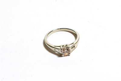 Lot 121 - A platinum diamond solitaire ring, a round brilliant cut diamond in a claw setting, to tapered...