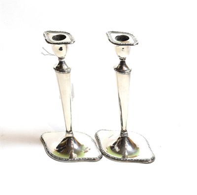 Lot 139 - ^ A pair of Edward VII silver candlesticks, by William Hutton and Sons, Sheffield, 1907, each...