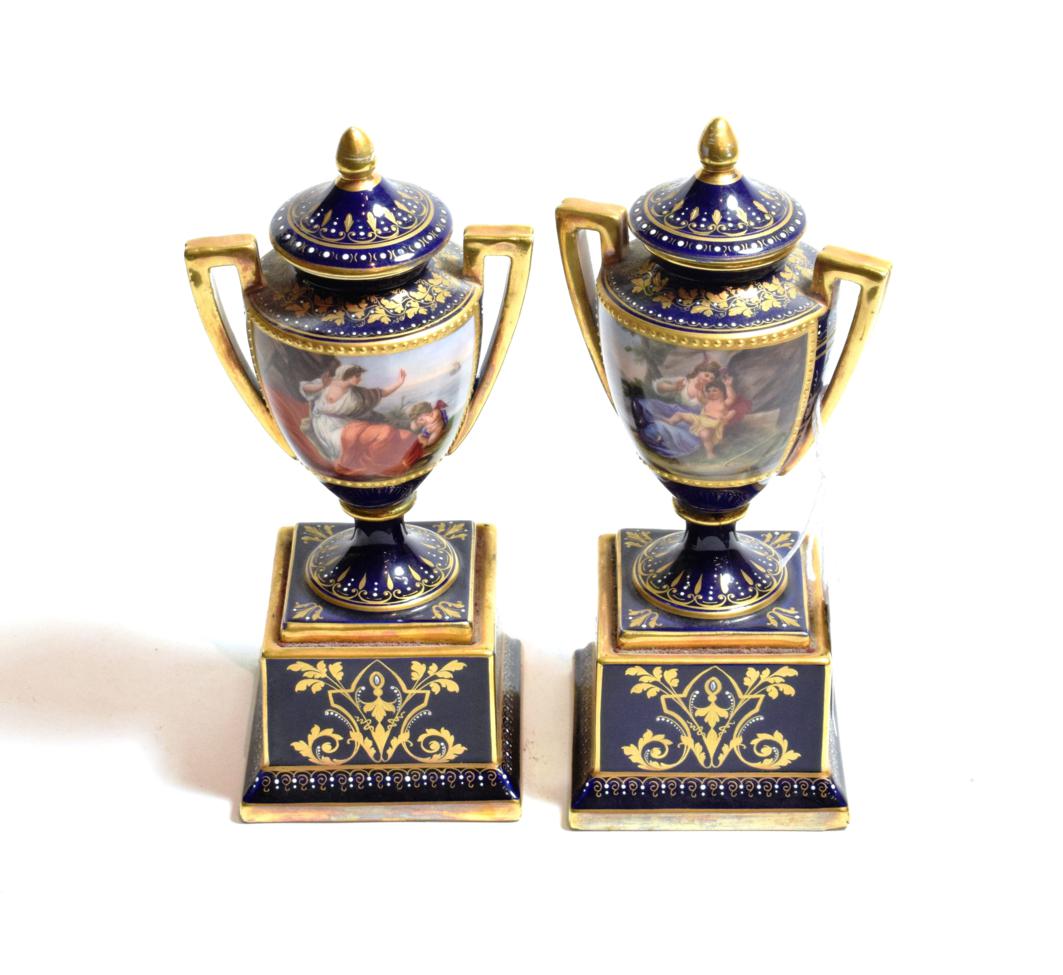 Lot 146 - ^ A pair of Vienna porcelain twin handled vases and covers, raised on square bases, dark blue...