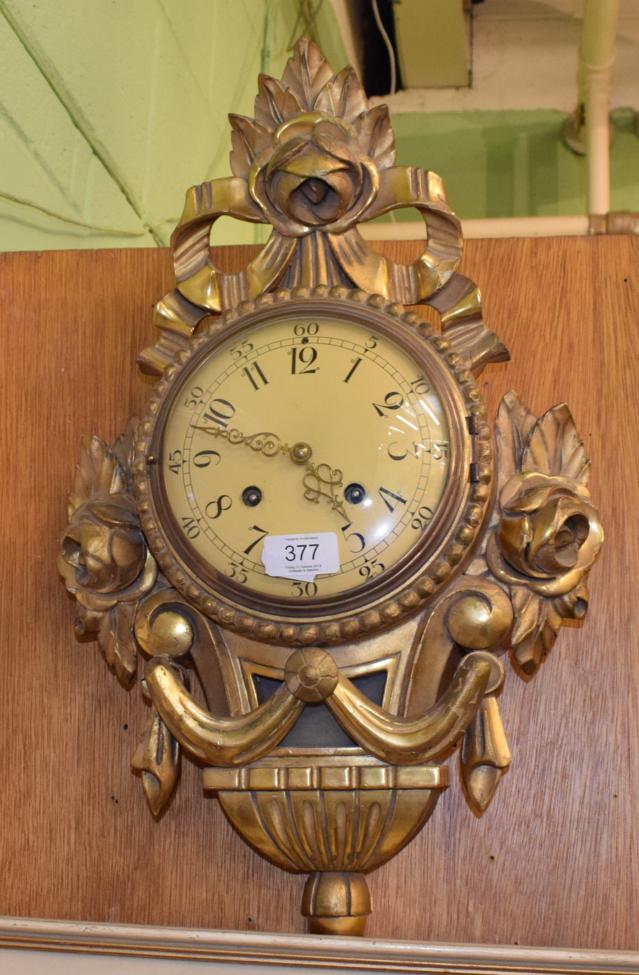 Lot 377 - A reproduction giltwood cartel clock