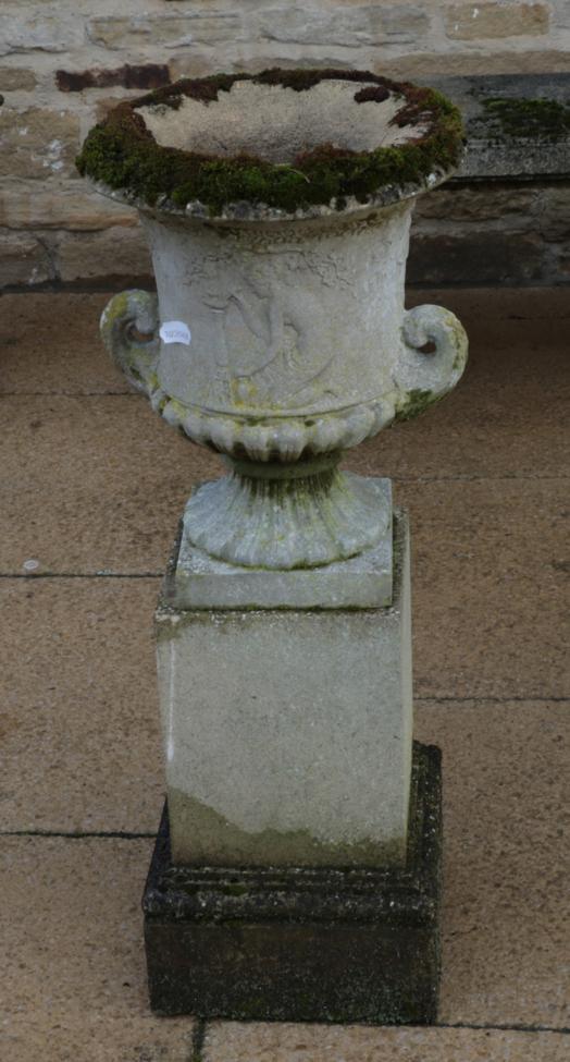 Lot 1109 - A weathered composition garden urn of campana form, on a stepped square plinth base