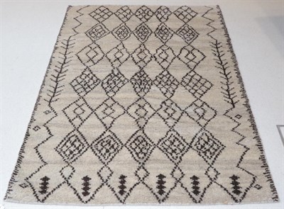 Lot 1129 - Modernist Morrocan Hand-Knotted Rug the abrashed natural field of stepped diamond lattice...