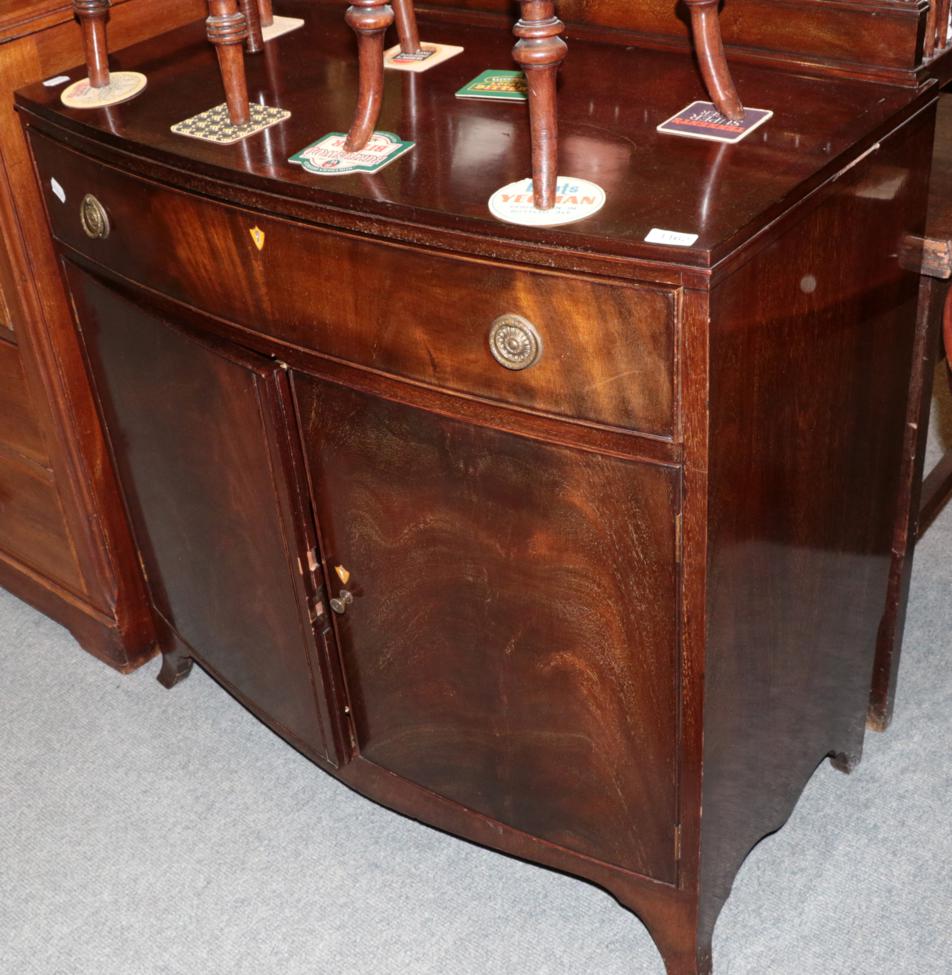 Lot 1162 - A George II style mahogany bow fronted cabinet with single drawer above two cupboard doors