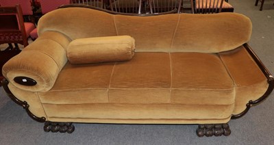 Lot 1211 - An early 20th century two seater scroll end sofa, upholstered in yellow velvet with carved claw...