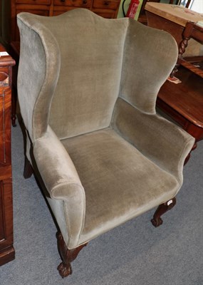 Lot 1278 - A George III style wing back armchair on ball and claw feet