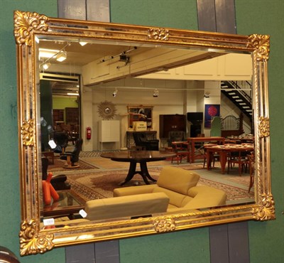 Lot 1309 - A reproduction gilt bevel glass mirror 89cm by 113cm