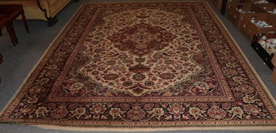 Lot 1311 - A machine made carpet of Oriental design, cream field with central medallion enclosed by floral...