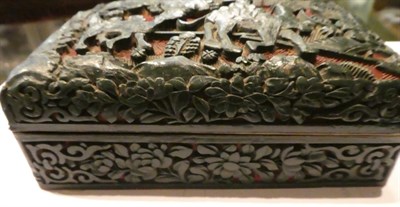 Lot 74 - A Chinese green and cinnabar tixi lacquer box and cover, carved with figures riding camels, a...