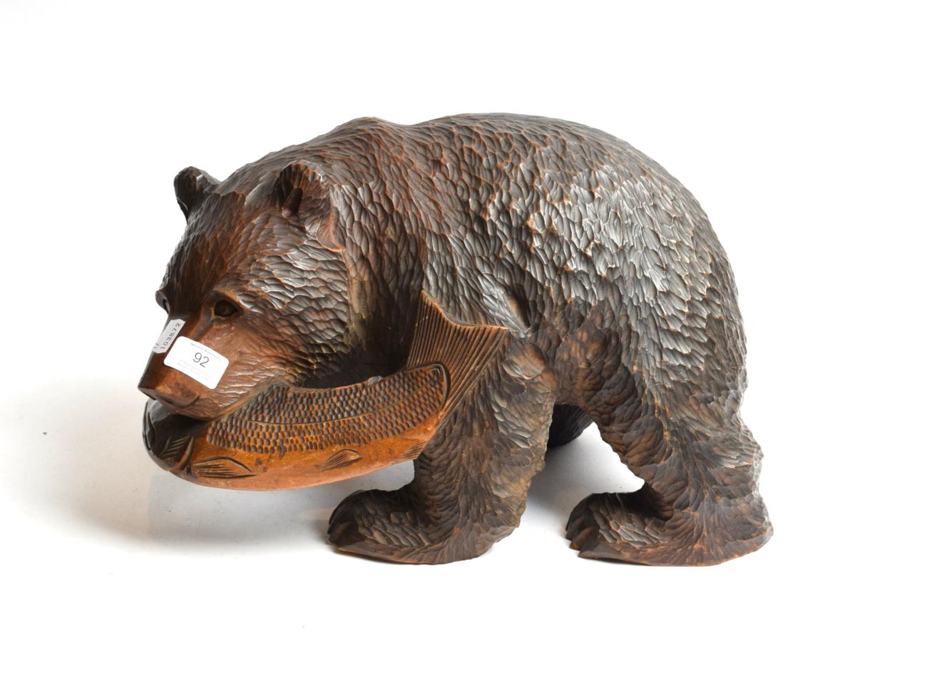 Lot 92 - A wooden carving of a bear catching salmon