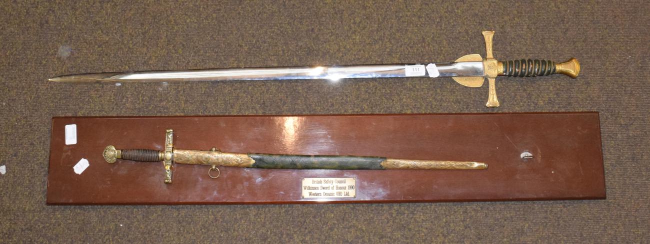 Lot 111 - An Elizabeth II presentation sword by Wilkinson Swords, the double edge steel blade etched with...