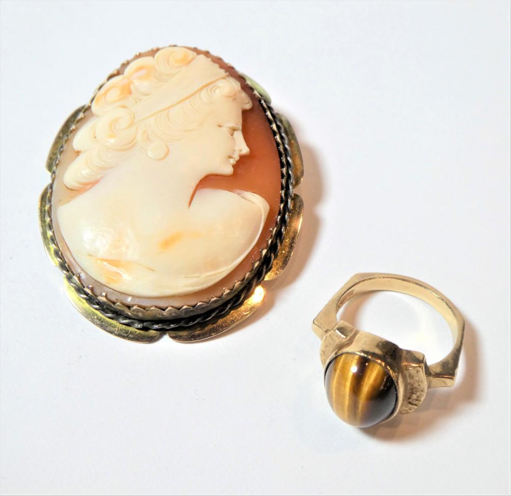 Lot 171 - A 9 carat gold tigers eye cabochon ring, finger size L; and a cameo brooch, frame stamped...