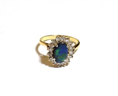 Lot 224 - A black opal and diamond cluster ring, stamped '18CT', finger size Q