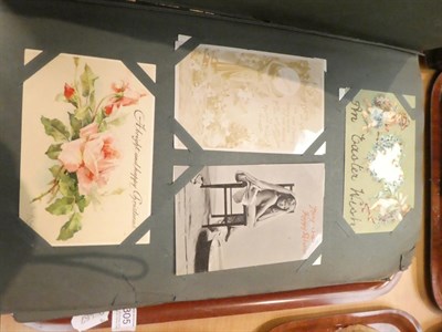 Lot 305 - An Edwardian postcard album filled with mainly coloured postcards, including greetings cards; a...