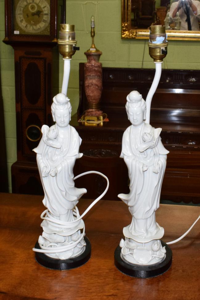 Lot 335 - A pair of blanc de chine table lamps each in the form of Guan Yin