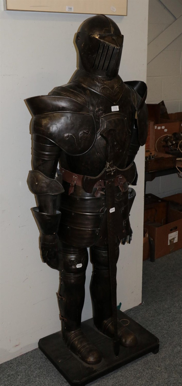 Lot 1115 - A reproduction suit of armour, holding a sword, on an ebonised plinth, 177cm high overall