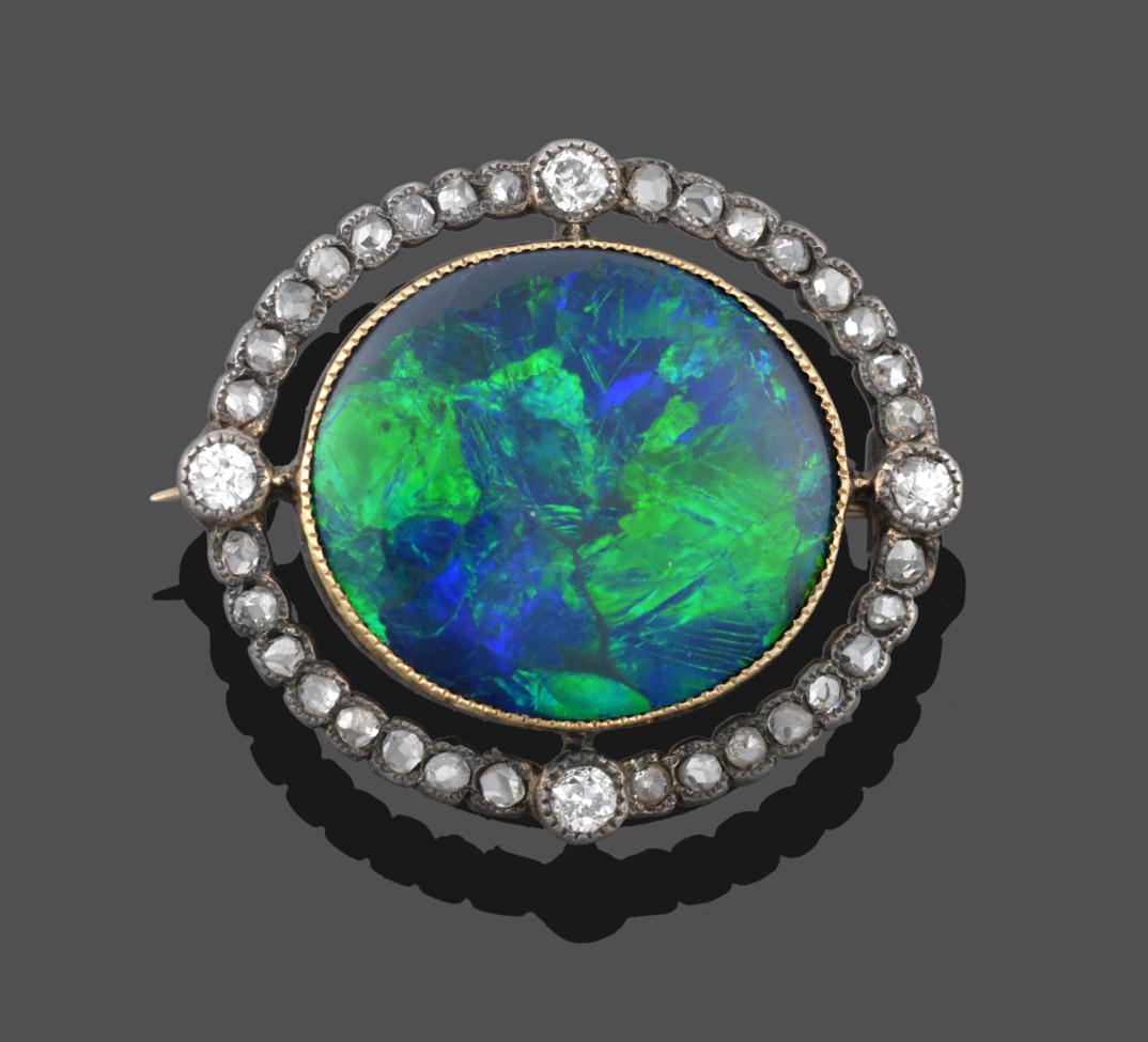 Lot 216 - An Opal and Diamond Brooch, circa 1910, an oval polished black opal in a yellow millegrain setting