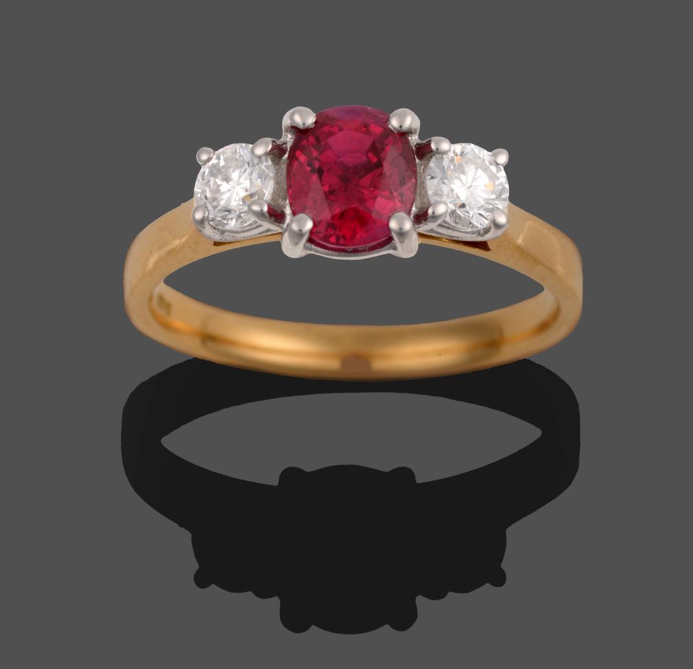 Lot 230 - An 18 Carat Gold Ruby and Diamond Three Stone Ring, the oval mixed cut ruby flanked by two...