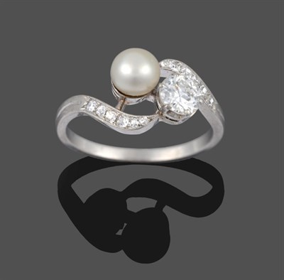 Lot 281 - A French Diamond and Pearl Twist Ring, the brilliant cut diamond in white claws, diagonally set...