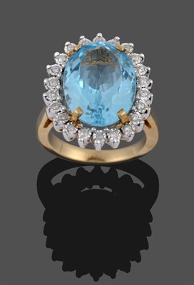 Lot 286 - A 9 Carat Gold Blue Topaz and Diamond Cluster Ring, an oval cut topaz in a yellow four claw...