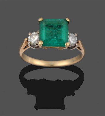 Lot 290 - An Emerald and Diamond Three Stone Ring, the emerald-cut emerald flanked by two round brilliant cut