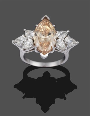 Lot 292 - A Fancy Diamond Ring, a light brown marquise cut diamond within two spray clusters of three...