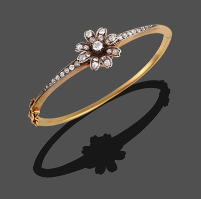 Lot 306 - A Diamond Set Bangle, circa 1900, old cut diamonds set to form a flowerhead, which sits atop a...