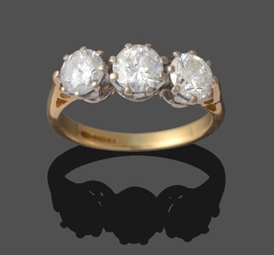 Lot 323 - A Diamond Three Stone Ring, the round brilliant cut diamond in white claw settings on a yellow...