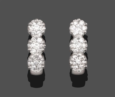 Lot 340 - A Pair of 18 Carat White Gold Diamond Earrings, a row of three clusters of round brilliant cut...