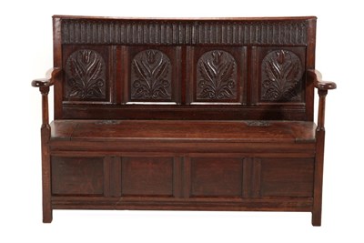 Lot 675 - A Joined Oak Settle, the nulled top rail above four fielded panels carved with tulips and...