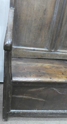 Lot 679 - An Early 18th Century Joined Oak Settle, the back support with four carved panels with five moulded