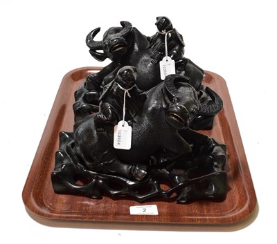 Lot 2 - A pair of Chinese carved hardwood boy and water buffalo figure groups; hardwood stands