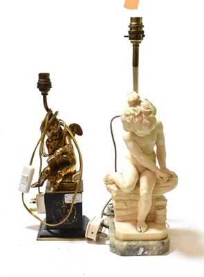 Lot 28 - A gilt metal cherub table lamp, on a black slate plinth; together with a figural table lamp of...