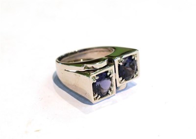 Lot 216 - An Art Deco style iolite two stone ring, the iolite stones in white double claw and channel...