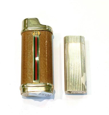 Lot 291 - A Cartier roller cigarette lighter No. N74286, together with a Gucci cigarette lighter (2)