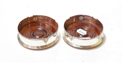 Lot 311 - A pair of Elizabeth II silver coasters, by K M Silver, Birmingham, 1998, cylindrical the shaped rim