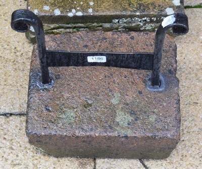 Lot 1186 - A cast iron boot scraper with scroll cast uprights, set in stone