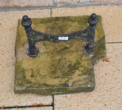 Lot 1187 - A cast iron boot scraper with urn form finials, set in stone