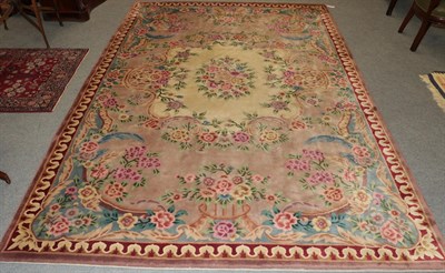 Lot 1200 - A large Chinese rug, the field with an ivory panel and floral sprays, surrounded by further...