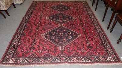 Lot 1207 - Kashgai Shiraz carpet, the crimson field of tribal motifs around a stepped medallion, framed by...