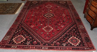 Lot 1208 - Kashgai Shiraz carpet, the raspberry field of stylised plants around three hooked medallions,...