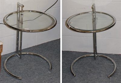 Lot 1218 - A pair of chromed tubular glass top circular lamp tables, modern, with adjustable height...