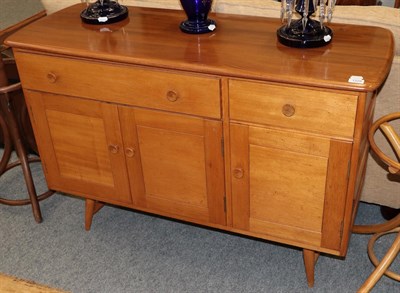 Lot 1228 - A 1970s Ercol elm sideboard with two drawers and three cupboard doors, 122cm wide