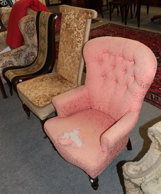 Lot 1335 - A Victorian upholstered armchair covered in pink button fabric; a Victorian prayer chair; and a...