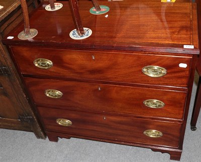 Lot 1357 - A late George III mahogany and tulipwood banded three-drawer, straight fronted chest of...