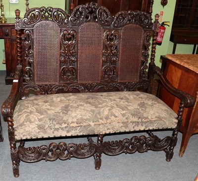 Lot 1391 - A Victorian carved walnut and cane back three-seater sofa, late 19th century, the foliate C...